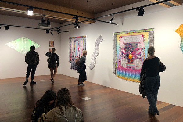 An image of pleated and printed digital textiles by artist Kate Geck created for the Pleated Parallax exhibiton at Melbourne Design Week in 2020. These are colourful, textural fabrics with internet iconography, glitch and digital detritus. Some of the panels had augmented reality markers embedded within them to play animated gifs.